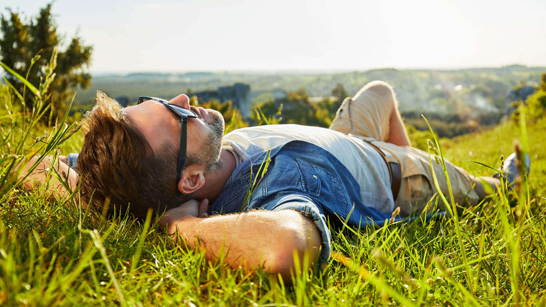 Man lying on grass enjoying peaceful sunny day.